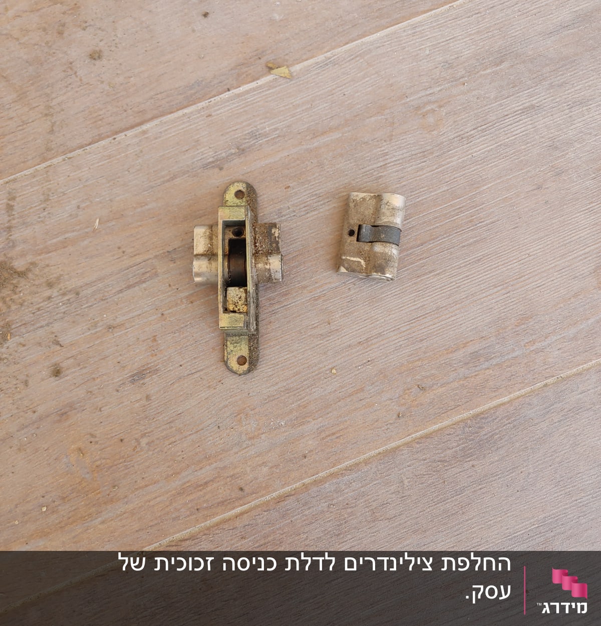 מנעול מתכת ישן וחלקים על רצפה עץ